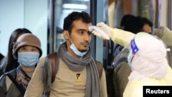 抵达利雅得的旅客在哈利德国王国际机场接受沙特卫生官员检测体温。（2020年1月29日）