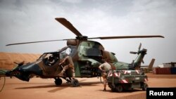 Des militaires français de l'opération Barkhane vérifient un hélicoptère Tigre à Gao au Mali le 1er août 2019.