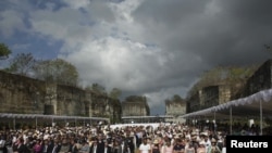 FILE - People pray during a minute of silence as part of a commemoration service for the 10th anniversary of the Bali bombing, Jimbaran, Bali, Oct. 12, 2012.