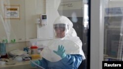 A laboratory specialist examines specimens of the Ebola virus at the Uganda virus research centre in Entebbe, May 17, 2011. 