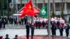In this photo released by Xinhua News Agency, policemen perform a flag-raising ceremony in Macao, Dec. 20, 2021, marking the 22nd anniversary of the former Portuguese colony's handover to Chinese rule. 