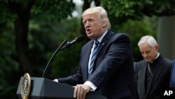President Donald Trump, accompanied by Washington Cardinal Donald Wuerl, speaks in the Rose Garden of the White House in Washington, May 4, 2017, before signing an executive order aimed at easing an IRS rule limiting political activity for churches. 