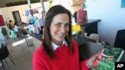 ModernWell founder and CEO Julie Burton poses at ModernWell in Minneapolis with a book she wrote in this January 16, 2019 photo. (AP Photo/Jim Mone)