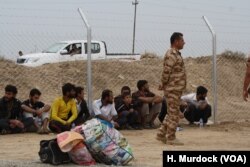Men arrive wearing beards and shortened trousers at the Khazir Camp in the Kurdish region of northern Iraq as Islamic State dictated in their village, Oct. 28, 2016.