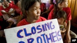 A Cambodian sex worker, center, holds a banner read " Closing Brothels" in a conference room for protest in Phnom Penh, Cambodia, file photo. 