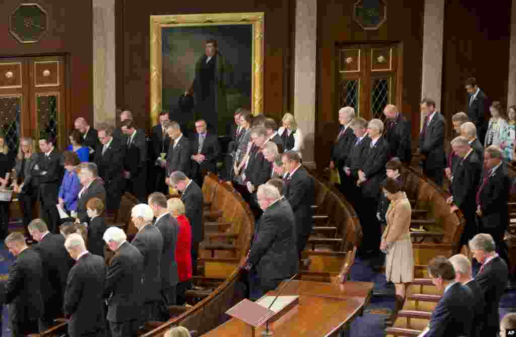 Members of the House of Representatives bow their heads during a prayer as they gather for the opening session of the 114th Congress on Capitol Hill in Washington, Jan. 6, 2105.