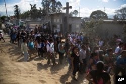 People accompany the burial of 14-year-old Madelyn Patricia Hernandez Hernandez, a girl who died in a fire at the Virgin of the Assumption Safe Home, at the Guatemala City's cemetery, March 10, 2017.