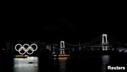 Kapal-kapal melintas di depan cincin-cincin raksasa Olimpiade di kawasan Odaiba Marine Park di Tokyo, Jepang, 2 April 2021.