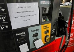A gasoline station posts signage saying that it has run out of unleaded and mid-grade fuel and has a $20 limit on super, at the pump in Atlanta, May 11, 2021.