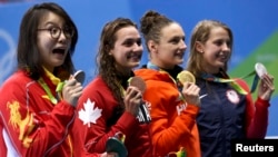 Fu Yuanhui (kiri) dan para perenang Olimpiade lainnya berpose dengan medali mereka setelah beradu di kompetisi gaya punggung 100m putri Senin (8/8).