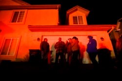 Residents and their friends watch neighboring homes burn as the Hillside fire tears through San Bernardino, Calif., on Thursday, Oct. 31, 2019.
