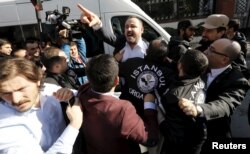 Plainclothes police officers scuffle with a protester outside the Kanalturk and Bugun TV building in Istanbul, Turkey, Oct. 28, 2015.