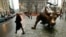 Seorang warga melintasi patung banteng dekat Wall Street di Distrik Finansial kota New York (foto: dok).