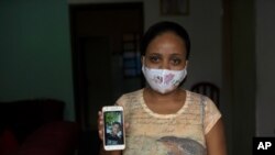 In this June 15, 2020 photo, Rafaela Matos shows a photo of her son João Pedro Matos Pinto, at her home in Sao Goncalo, who was killed on May 18 when police burst into his aunt's house and shot the 14-year-old in the stomach.
