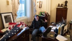 លោក Richard Barnett អ្នក​គាំទ្រ​ម្នាក់​របស់​លោក​ប្រធានាធិបតី Donald Trump អង្គុយ​នៅ​ក្នុង​ការិយាល័យ​របស់​ប្រធាន​រដ្ឋសភា​អ្នកស្រី Nancy Pelosi ខណៈ​ដែល​លោក​តវ៉ា​នៅ​ក្នុង​វិមាន​សភា​ក្នុង​រដ្ឋធានី​វ៉ាស៊ីនតោន ថ្ងៃទី៦ ខែមករា ឆ្នាំ២០២១។