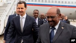 Presiden Suriah Bashar al-Assad (kiri) menerima kunjungan Presiden Omar al-Bashir di Damaskus, Minggu (16/12).