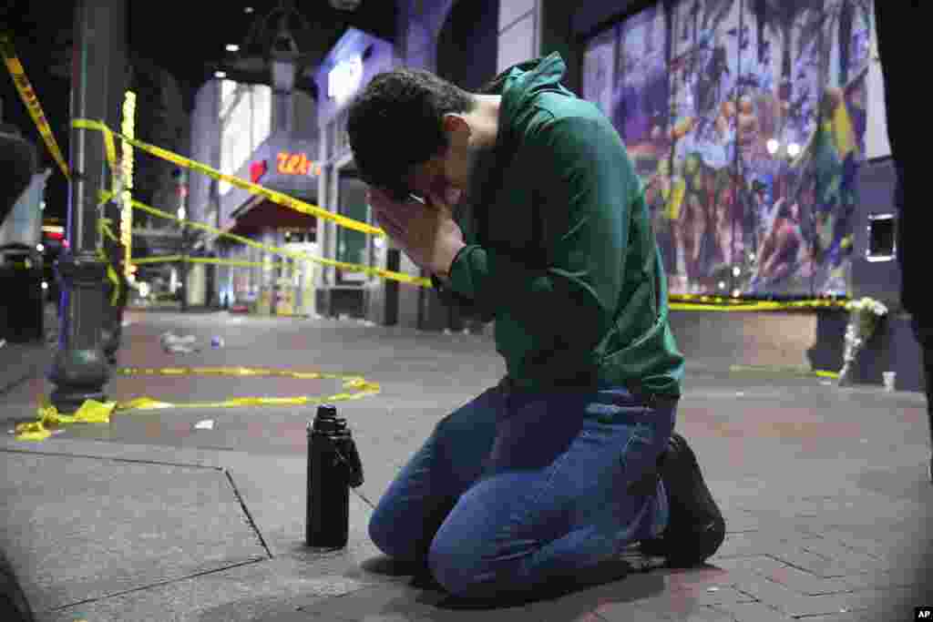 Matthias Hauswirth of New Orleans prays on the street near the scene where a vehicle drove into a crowd on New Orleans&#39; Canal and Bourbon streets, Jan. 1, 2025.