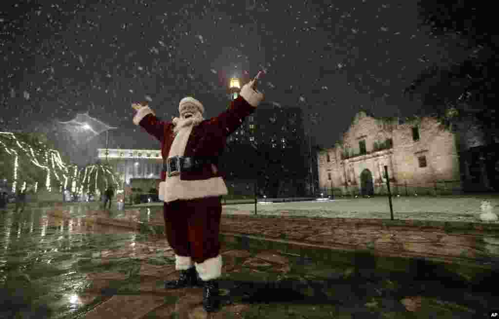 在美国圣安东尼奥市中心降雪时，装扮成圣诞老人的Eldon Hansen站在阿拉莫前面（2017年12月7日）。