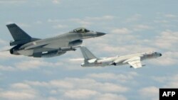 This handout photograph taken and released on May 11, 2018 by Taiwan's Defence Ministry shows a Republic of China (Taiwan) Air Force F-16 fighter aircraft (L) flying alongside a Chinese People's Liberation Army Air Force (PLAAF) H-6K bomber. (AFP)