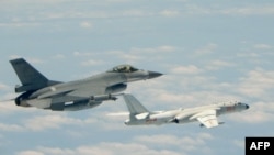 Gambar yang diambil dan dirilis oleh Kementerian Pertahanan Taiwan menunjukkan pesawat tempur F-16 (kiri) Taiwan terbang bersama Angkatan Udara Tentara Pembebasan Rakyat China (PLAAF), sebagai illustrast. (Foto: AFP)