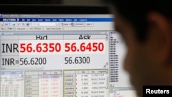 Seorang pedagang mata uang mengamati layar yang menunjukkan nilai Rupee India terhadap Dolar AS di Mumbai (31/5).