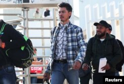 Central American asylum seekers exit the Chaparral border crossing gate after being sent back to Mexico by the U.S. in Tijuana, Mexico, Jan. 30, 2019.