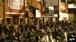 People walk along Main Street during the 80th Annual Sturgis Motorcycle Rally in Sturgis, S.D., Aug. 8, 2020. The rally usually attracts around 500,000 people; officials estimate the coronavirus will trim that to 250,000 this year.