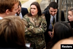 In a borrowed U.S. Army jacket to keep warm, White House press secretary Sarah Huckabee Sanders updates reporters on President Donald Trump's failed attempt, preempted by weather, to visit Observation Post Ouellette along the Demilitarized Zone (DMZ) in the truce village of Panmunjom dividing North Korea and South Korea outside Seoul, South Korea, Nov. 8, 2017.