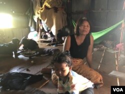 Om Samath, 53, a resident of Siem Reap City’s Chreav commune, looks after her grandchildren while their parents are at work. March 15, 2019. (Sun Narin/VOA Khmer)