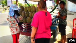 លោកទូច អួច​ (នៅ​ស្តាំដៃ) កំពុង​លក់​ផ្លែទុរេន​ នៅតាមបណ្តោយ​ផ្លូវ​សហព័ន្ធ​រុស្ស៊ី​ ថ្ងៃទី​៧ ខែឧសភា​ ឆ្នាំ​២០២០។ (ហ៊ុល រស្មី​/វីអូអេខ្មែរ) 