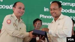 Om Yentieng, head of the government Anti-Corruption Unit, hands award to an outstanding reporter on corruption in Phnom Penh, July 22, 2015. (Hean Socheata/VOA Khmer)