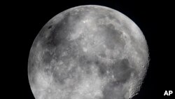 In this early Monday, Oct. 5, 2020, file photo, a waning moon is seen at the sky over Frankfurt, Germany. The moon’s shadowed, frigid nooks and crannies may hold frozen water in more places and in larger quantities than previously suspected. (AP Photo/Michael Probst, File)