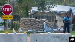 FILE - Pakistan police officers man a checkpoint outside the house of former President of Pakistan Pervez Musharraf, where he has been held under house arrest, in Islamabad, Oct 10, 2013. 