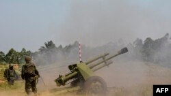 Des soldats des FARDC tirent à Matombo, 35 kilomètres au nord de Beni, dans le Nord-Kivu, le 13 janvier 2018.