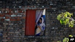 A Christian woman prays during a special Easter service led by a pastor from her house due to a government-imposed lockdown to help stop the spread of the new coronavirus, at a Christian neighborhood of Islamabad, April 12, 2020.