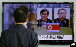 한국 서울역에 설치된 TV에서 북한 당국에 체포돼 억류 중인 한국 국민 김국기(왼쪽)씨와 최춘길 씨에 관한 뉴스가 나오고 있다.