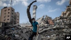 Seorang pria Palestina memeriksa bangunan enam lantai yang hancur akibat serangan udara Israel di Kota Gaza, Selasa dini hari, 18 Mei 2021. (AP)
