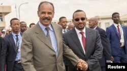 FILE - Eritrean President Isaias Afwerki and Ethiopia's Prime Minister Abiy Ahmed walk together at Asmara International Airport, Eritrea, July 9, 2018.