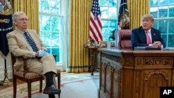Senate Majority Leader Mitch McConnell listens as President Donald Trump speaks during a meeting in the Oval Office of the White House, July 20, 2020, in Washington.
