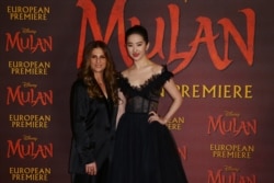 Actress Yifei Liu, right, and Director Niki Caro, left, pose for photographers upon arrival at the European Premiere of 'Mulan' at a central London cinema, March 12, 2020.