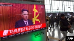 Orang-orang berlalu di samping siaran berita televisi di stasiun kereta api yang menampilkan pidato Tahun Baru Pemimpin Korea Utara, Kim Jong-Un. (foto: AFP PHOTO/ JUNG Yeon-Je)