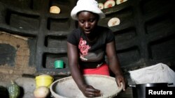 FILE - A woman prepares sorghum for food at her home in drought-hit Masvingo, Zimbabwe, June 1,2016. 