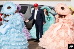 President-elect Donald Trump is greeted by the Azalea Trail Maids — 50 high school seniors chosen yearly to serve as ambassadors for the city of Mobile, Ala. — after arriving at the airport for a rally at Ladd-Peebles Stadium, Dec. 17, 2016.
