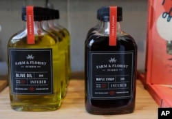 FILE - Bottles of maple syrup and olive oil infused with CBD marijuana extract are displayed for sale at the Village Bloomery medical cannabis dispensary in Vancouver, British Columbia, Sept. 25, 2018.