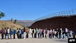 지난 5일 캘리포니아주 하쿰바 핫스프링스의 국경 장벽을 넘어온 이주자들이 줄을 서 있다. (자료사진)