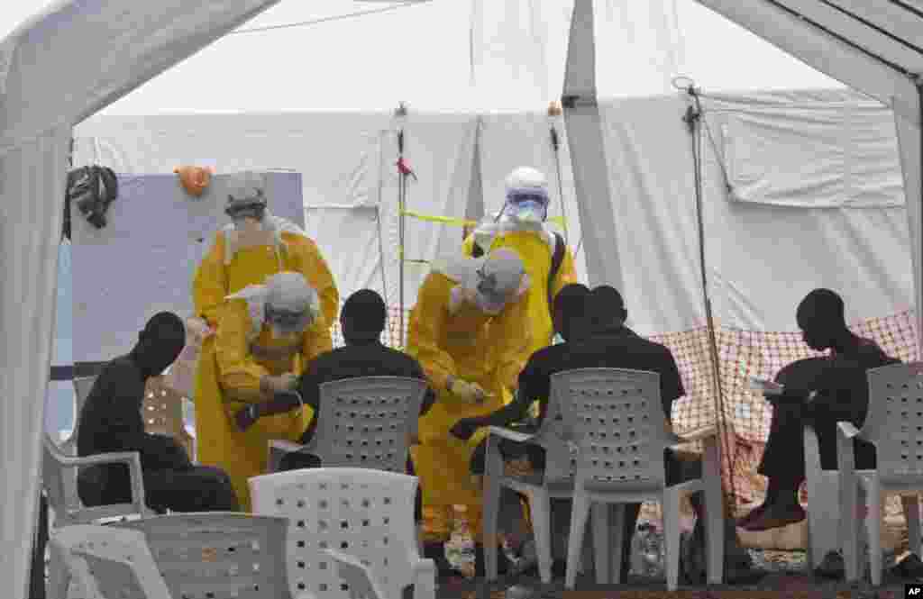 Health workers care for patients infected with the Ebola virus, at a clinic in Monrovia, Liberia, Sept. 8, 2014.&nbsp;