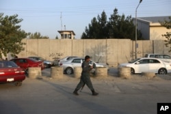 FILE - An Afghan security official patrols after an attack on the American University of Afghanistan in Kabul, Afghanistan, Aug. 25, 2016.