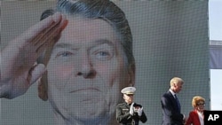 Former first lady Nancy Reagan is helped on stage by Frederick J. Ryan Jr., center, Reagan Foundation Chairman, as Marine Lt. Gen. George J. Flynn looks on after a wreath laying ceremony at memorial of her husband, former US President Ronald Reagan during