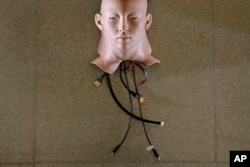 In this Sept. 28, 2017, photo, a robot head is covered by Hanson Robotics' skin, in Hong Kong.
