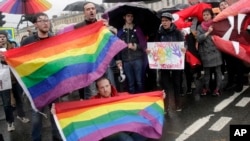 FILE – Gay rights activists attend a rally in St. Petersburg, Russia, May 1, 2018. Tolerated during the World Cup, Russia’s LGBT communities face a near certain return of widespread discrimination when the competition packs up and leaves the country in mid-July.
